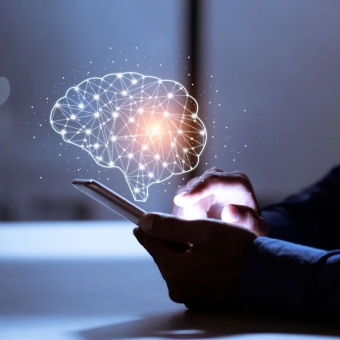 Eine Person tippt auf ihrem Smartphone und über dem Display ist eine Abbildung zusehen, die das neuronale Netzwerk des Gehirns darstellen soll