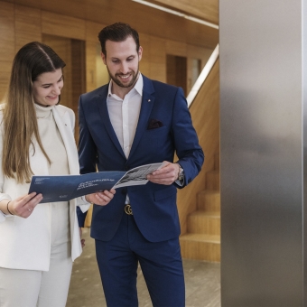 Zwei Personen schauen sich ein Prospekt an.