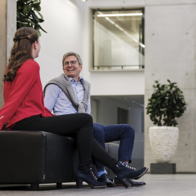Zwei Mitarbeiter*innen sitzen in der BTV Stadtforum Filiale und befinden sich in einem Gespräch.